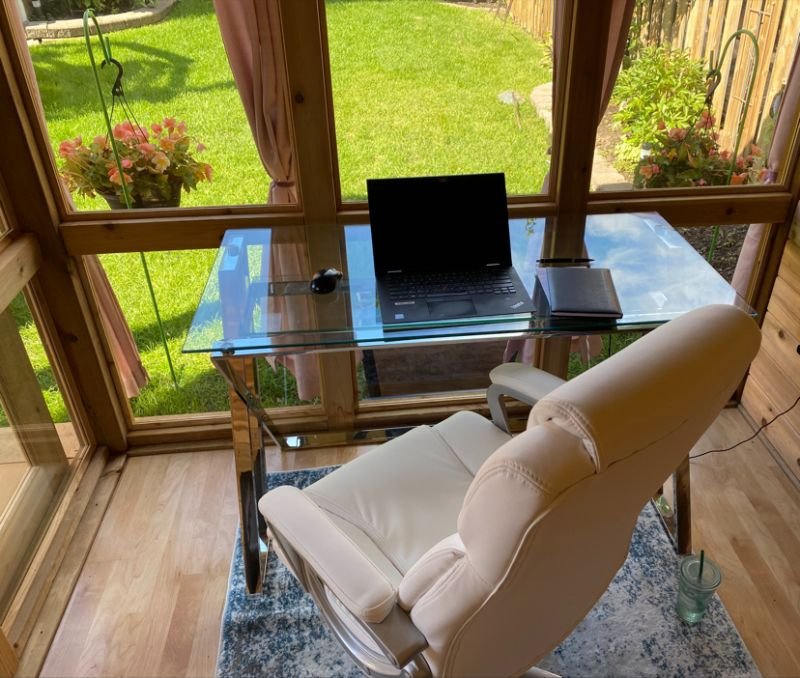 computer sitting on a glass desk and a white chair