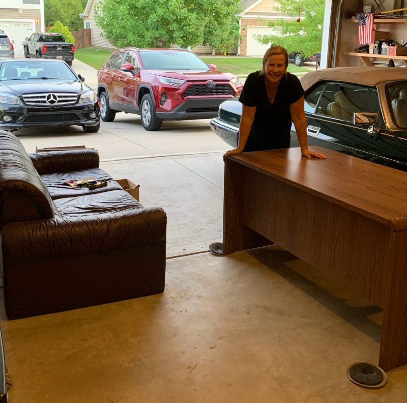 Kelley standing in the garage with furniture