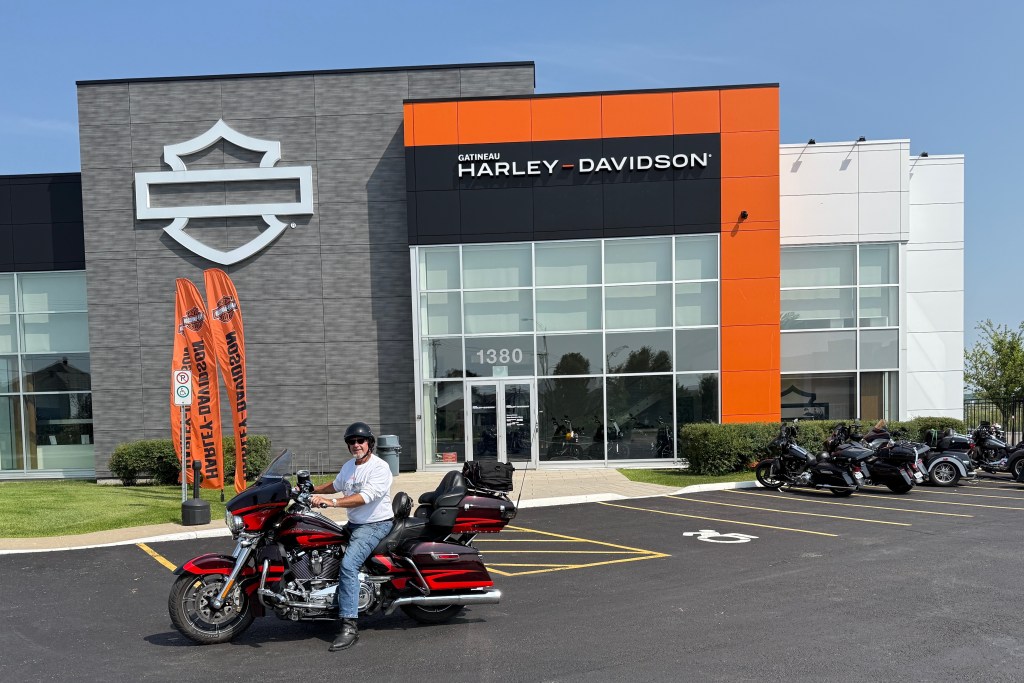 Les sitting on a motorcycle at Gatineau Harley Davidson dealer