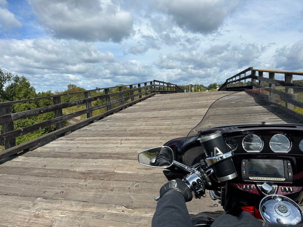 Motorcycle riding across a wooden bridge