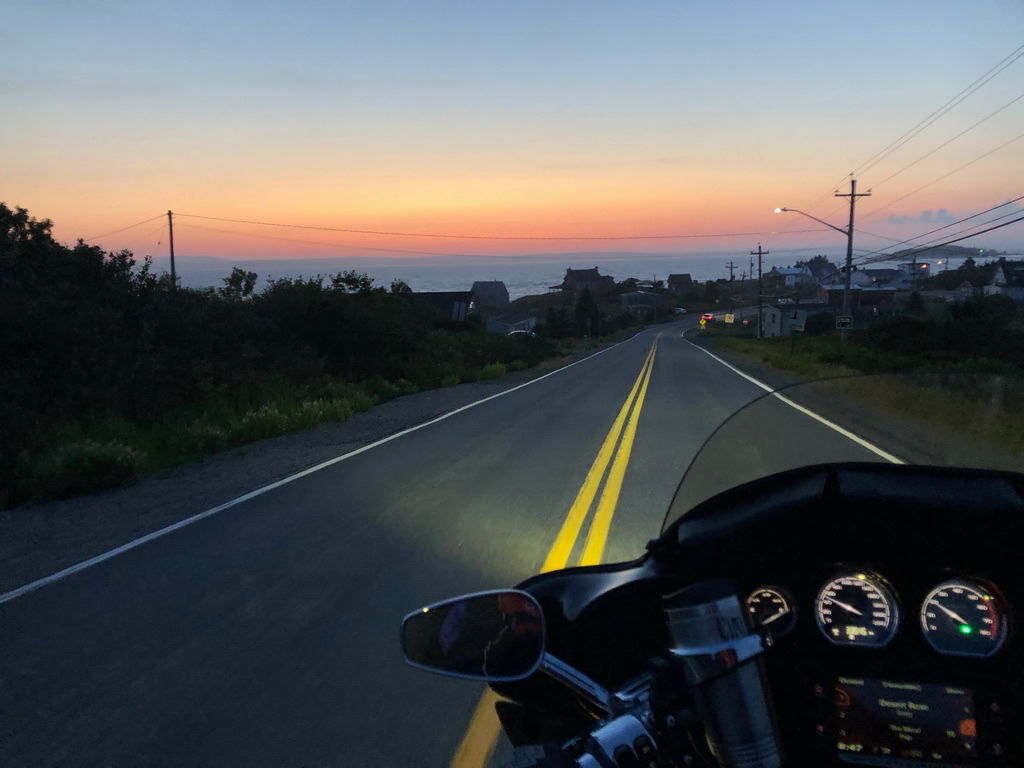 Motorcycle riding into Peggy's Cove at sunset
