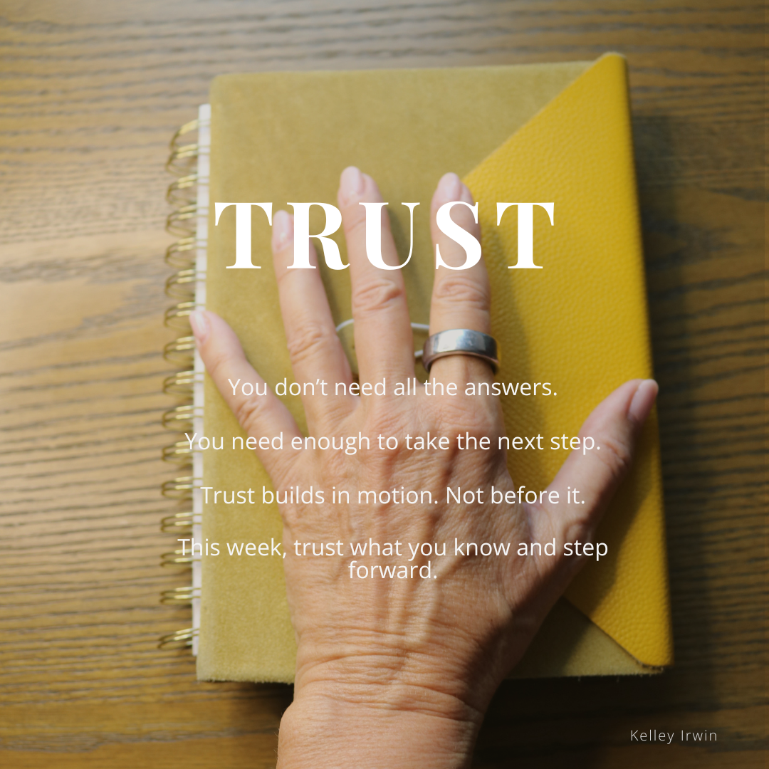 Word TRUST on top of hand placed on a book on the wooden desk